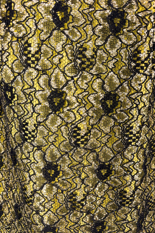 Vintage 1960s cocktail dress with sheer black lace layered over a bright yellow lining. The dress is sleeveless, with straps that narrow towards the back, and a wide, round neckline. Closes in the back with a cotton twill zipper.