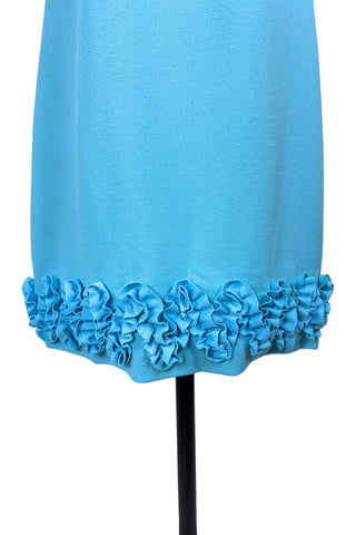 Vintage 1960s dress in cornflower blue textured crepe with a wide zigzag ruffle trim along the hem. The dress is sleeveless, with a round neckline.

The dress closes in the back with a metal zipper, and is unlined.

Designed by Nancy G. “That Young Sophisticated Look”.