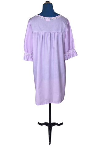 Vintage 1960s housecoat in lilac purple cotton blend with delicate white eyelet lace detail across the bust, and trimming the three-quarter length sleeves. The sleeves have gathered ruffle cuffs. The round neckline is trimmed with a tiny white lace ruffle. 

Designed by Adorable Lingerie. Marked size Medium.