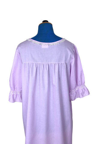 Vintage 1960s housecoat in lilac purple cotton blend with delicate white eyelet lace detail across the bust, and trimming the three-quarter length sleeves. The sleeves have gathered ruffle cuffs. The round neckline is trimmed with a tiny white lace ruffle. 

Designed by Adorable Lingerie. Marked size Medium.
