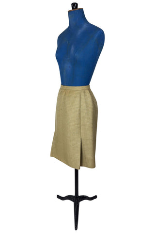 Vintage 1960s skirt suit with oversized jacket and matching skirt. The jacket features three-quarter length sleeves, bow accents at the waist, and closes with two large textured lucite buttons. The skirt has a pleat panel in the front, and closes in the back with a metal zipper.

The jacket and skirt are both lined in caramel brown rayon.

The jacket has a few light stains on the front, which would likely be removed with dry cleaning.