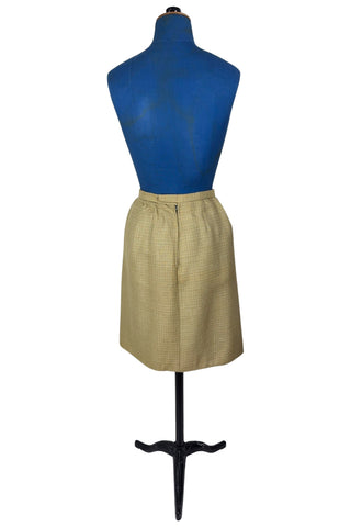 Vintage 1960s skirt suit with oversized jacket and matching skirt. The jacket features three-quarter length sleeves, bow accents at the waist, and closes with two large textured lucite buttons. The skirt has a pleat panel in the front, and closes in the back with a metal zipper.

The jacket and skirt are both lined in caramel brown rayon.

The jacket has a few light stains on the front, which would likely be removed with dry cleaning.