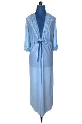Vintage 1970s negligee robe in sky blue with wide lace trim along the deep V neckline and three-quarter length sleeve cuffs. Finished with a decorative royal blue bow. Closes at the waist with a single button.