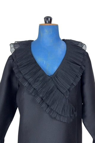 Vintage 1960s Lillie Rubin black cocktail dress with sheer, accordion pleated chiffon ruffle collar. The long sleeves have matching double-layered chiffon pleated cuffs. This amazing little black dress is perfect for any cocktail party or night on the town.

Closes in the back with a metal zipper.

Designed by Lillie Rubin.