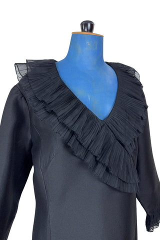 Vintage 1960s Lillie Rubin black cocktail dress with sheer, accordion pleated chiffon ruffle collar. The long sleeves have matching double-layered chiffon pleated cuffs. This amazing little black dress is perfect for any cocktail party or night on the town.

Closes in the back with a metal zipper.

Designed by Lillie Rubin.