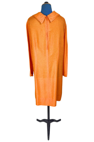 Vintage 1960s orange textured mod dress with long sleeves, large pointed collar, and two decorative rhinestone buttons. The long sleeves have turned cuffs. The A-line dress has bust darts through the sides and diagonally down towards the hips. Closes in the back with a cotton twill zipper.