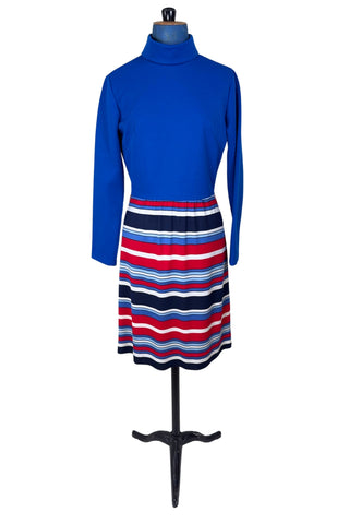 Vintage 1960s day dress with turtleneck rolled collar, long sleeves, and contrasting striped skirt in red, white and blue. Closes in the back with a cotton twill zipper. 

Designed by JC Penney Fashions.