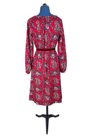 Vintage 1970s bohemian dress with paisley print on a rich red background. The dress is made from cotton, and  features a round, elasticized neckline and long sleeves with elasticized cuffs. There are no closures, it is a pullover style.