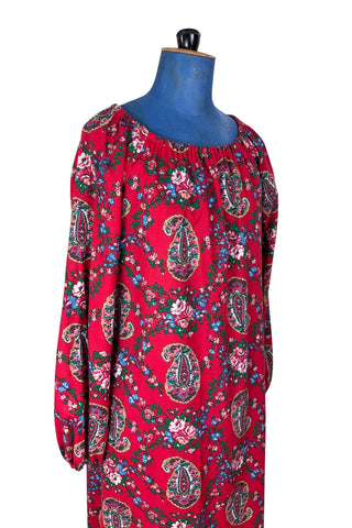 Vintage 1970s bohemian dress with paisley print on a rich red background. The dress is made from cotton, and  features a round, elasticized neckline and long sleeves with elasticized cuffs. There are no closures, it is a pullover style.
