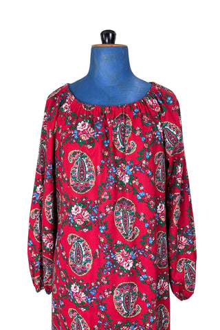 Vintage 1970s bohemian dress with paisley print on a rich red background. The dress is made from cotton, and  features a round, elasticized neckline and long sleeves with elasticized cuffs. There are no closures, it is a pullover style.