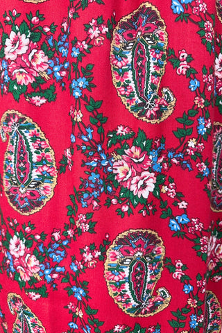 Vintage 1970s bohemian dress with paisley print on a rich red background. The dress is made from cotton, and  features a round, elasticized neckline and long sleeves with elasticized cuffs. There are no closures, it is a pullover style.