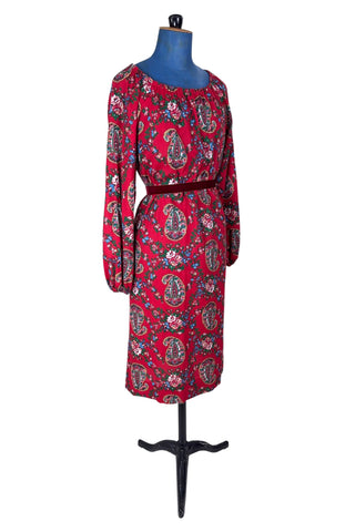 Vintage 1970s bohemian dress with paisley print on a rich red background. The dress is made from cotton, and  features a round, elasticized neckline and long sleeves with elasticized cuffs. There are no closures, it is a pullover style.