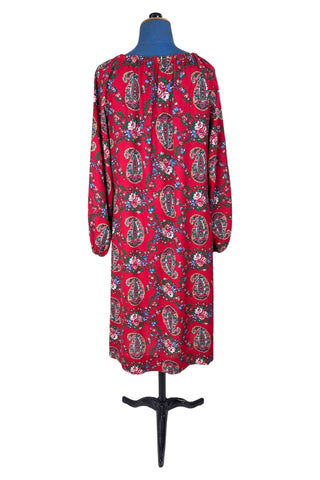 Vintage 1970s bohemian dress with paisley print on a rich red background. The dress is made from cotton, and  features a round, elasticized neckline and long sleeves with elasticized cuffs. There are no closures, it is a pullover style.