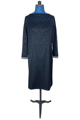 Vintage 1960s cocktail dress in black corded lace with see-through upper bodice and sleeves. The long sleeves are embellished with silver corded soutache trim. The dress closes in the back with a cotton twill zipper, and is fully lined.
