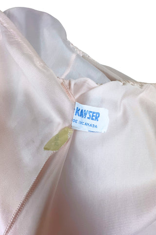 Vintage 1950s Kayser half slip in light pink with grey scalloped lace trim. The bottom of the slip is decorated with a wide panel of overlay chiffon embroidered with a floral chain. The waist is elasticized.

Designed by Kayser. Made in Canada. Marked size Small / Short.