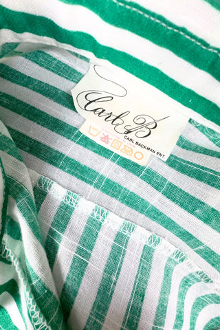 Vintage 1980s button down shirt with white and green stripes. Features short sleeves and wide faux-pocket flaps with button closures. Can be worn fully buttoned or with an open neckline for two distinct looks.

Designed by Carl B (Carl Backman Ent.). Made in Canada. 