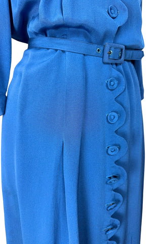 Vintage 1940s day dress in royal blue rayon with scalloped collar and front button placket, which closes with 14 functional self-fabric buttons down the front. The dress has three quarter sleeves with folded cuffs, and a matching self-fabric belt with a rectangular covered buckle. 
Condition Note: The dress is in very good vintage condition, with an inconspicuous small darkened area on the lower back of the skirt about 1-2” long.