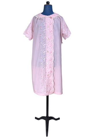 Vintage late 1950s robe in light pink with large scalloped eyelet embroidery down the front and around the short sleeves. The peignoir style robe features short sleeves with matching openwork floral embroidery, and a Peter Pan collar trimmed with dainty white lace. The robe closes with five flat ivory pearl buttons, and a hidden snap under the collar.

A Perri-Ann design by Faris. Made in Canada.
