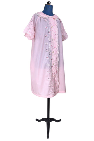 Vintage late 1950s robe in light pink with large scalloped eyelet embroidery down the front and around the short sleeves. The peignoir style robe features short sleeves with matching openwork floral embroidery, and a Peter Pan collar trimmed with dainty white lace. The robe closes with five flat ivory pearl buttons, and a hidden snap under the collar.

A Perri-Ann design by Faris. Made in Canada.