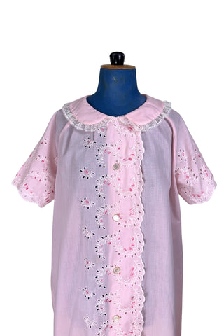 Vintage late 1950s robe in light pink with large scalloped eyelet embroidery down the front and around the short sleeves. The peignoir style robe features short sleeves with matching openwork floral embroidery, and a Peter Pan collar trimmed with dainty white lace. The robe closes with five flat ivory pearl buttons, and a hidden snap under the collar.

A Perri-Ann design by Faris. Made in Canada.