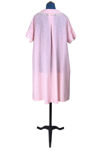 Vintage late 1950s robe in light pink with large scalloped eyelet embroidery down the front and around the short sleeves. The peignoir style robe features short sleeves with matching openwork floral embroidery, and a Peter Pan collar trimmed with dainty white lace. The robe closes with five flat ivory pearl buttons, and a hidden snap under the collar.

A Perri-Ann design by Faris. Made in Canada.