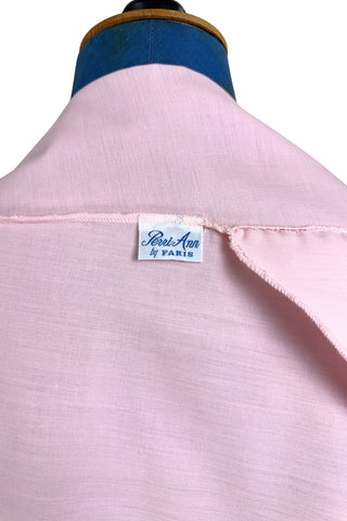 Vintage late 1950s robe in light pink with large scalloped eyelet embroidery down the front and around the short sleeves. The peignoir style robe features short sleeves with matching openwork floral embroidery, and a Peter Pan collar trimmed with dainty white lace. The robe closes with five flat ivory pearl buttons, and a hidden snap under the collar.

A Perri-Ann design by Faris. Made in Canada.