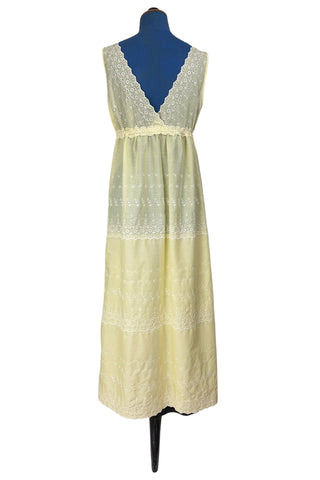 Vintage 1960s nightgown in yellow cotton with white eyelet embroidery. The nightgown is sleeveless, with a deep V neckline and gathered empire waist which ties with a yellow ribbon woven through eyelet lace trim. The back of the nightgown has a similar deep V cut.