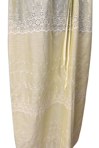 Vintage 1960s nightgown in yellow cotton with white eyelet embroidery. The nightgown is sleeveless, with a deep V neckline and gathered empire waist which ties with a yellow ribbon woven through eyelet lace trim. The back of the nightgown has a similar deep V cut.