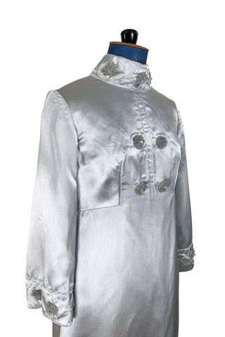 Vintage 1960s evening gown in silver grey heavy silk satin with large beaded medallion clusters and delicate silver beaded ‘vines’. The gown features a high neckline, empire waist (notice the unique inset bust darts), long sleeves with wide cuffs, and a gently flared A-line full length skirt.

Closes in the back with a cotton twill nylon coil Lightning zipper. Fully lined with soft cornflower blue silk.