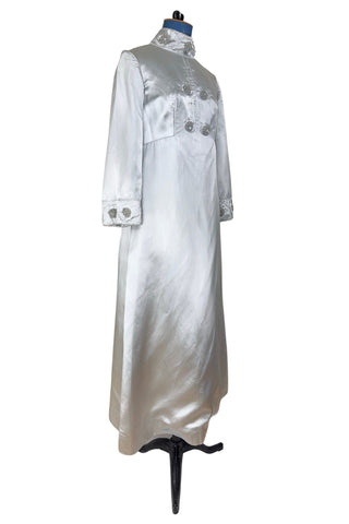 Vintage 1960s evening gown in silver grey heavy silk satin with large beaded medallion clusters and delicate silver beaded ‘vines’. The gown features a high neckline, empire waist (notice the unique inset bust darts), long sleeves with wide cuffs, and a gently flared A-line full length skirt.

Closes in the back with a cotton twill nylon coil Lightning zipper. Fully lined with soft cornflower blue silk.