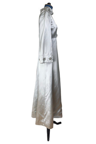 Vintage 1960s evening gown in silver grey heavy silk satin with large beaded medallion clusters and delicate silver beaded ‘vines’. The gown features a high neckline, empire waist (notice the unique inset bust darts), long sleeves with wide cuffs, and a gently flared A-line full length skirt.

Closes in the back with a cotton twill nylon coil Lightning zipper. Fully lined with soft cornflower blue silk.
