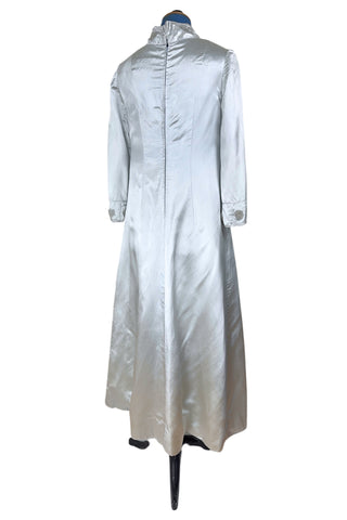 Vintage 1960s evening gown in silver grey heavy silk satin with large beaded medallion clusters and delicate silver beaded ‘vines’. The gown features a high neckline, empire waist (notice the unique inset bust darts), long sleeves with wide cuffs, and a gently flared A-line full length skirt.

Closes in the back with a cotton twill nylon coil Lightning zipper. Fully lined with soft cornflower blue silk.