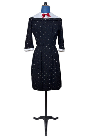 Unique true vintage 1950s “secretary” dress with detachable collar and cuffs for easy washing and ironing. The dress is made of black cotton (may have some linen content as well) with tiny white arc shaped embroidered polkadots. The collar and cuffs are made of crisp white linen/cotton, and attach with a series of metal snaps around the neckline and cuffs. The collar has a set of two bound buttonholes that a ribbon or scarf may be threaded through. The dress can be worn with any combination of collar,...