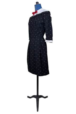 Unique true vintage 1950s “secretary” dress with detachable collar and cuffs for easy washing and ironing. The dress is made of black cotton (may have some linen content as well) with tiny white arc shaped embroidered polkadots. The collar and cuffs are made of crisp white linen/cotton, and attach with a series of metal snaps around the neckline and cuffs. The collar has a set of two bound buttonholes that a ribbon or scarf may be threaded through. The dress can be worn with any combination of collar,...