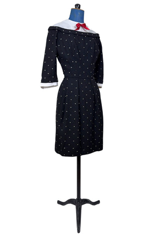Unique true vintage 1950s “secretary” dress with detachable collar and cuffs for easy washing and ironing. The dress is made of black cotton (may have some linen content as well) with tiny white arc shaped embroidered polkadots. The collar and cuffs are made of crisp white linen/cotton, and attach with a series of metal snaps around the neckline and cuffs. The collar has a set of two bound buttonholes that a ribbon or scarf may be threaded through. The dress can be worn with any combination of collar,...
