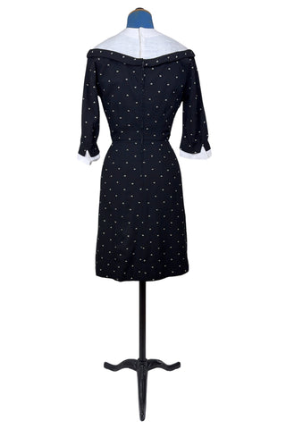 Unique true vintage 1950s “secretary” dress with detachable collar and cuffs for easy washing and ironing. The dress is made of black cotton (may have some linen content as well) with tiny white arc shaped embroidered polkadots. The collar and cuffs are made of crisp white linen/cotton, and attach with a series of metal snaps around the neckline and cuffs. The collar has a set of two bound buttonholes that a ribbon or scarf may be threaded through. The dress can be worn with any combination of collar,...