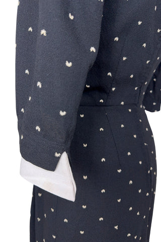 Unique true vintage 1950s “secretary” dress with detachable collar and cuffs for easy washing and ironing. The dress is made of black cotton (may have some linen content as well) with tiny white arc shaped embroidered polkadots. The collar and cuffs are made of crisp white linen/cotton, and attach with a series of metal snaps around the neckline and cuffs. The collar has a set of two bound buttonholes that a ribbon or scarf may be threaded through. The dress can be worn with any combination of collar,...
