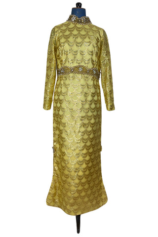 Absolutely stunning true vintage 1960s evening gown in gold metallic figured sheer chiffon, with intricate heavy beading at the high neckline and waist, with large beaded medallion clusters at the tops of the side slits in the skirt. The dress is lined through the bodice and skirt, while the sleeves are left unlined to highlight the sheer gold fabric. 

Designed and made by Fontana’s New York. 

The dress closes in the back with a cotton twill nylon zipper.