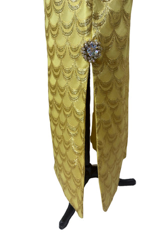 Absolutely stunning true vintage 1960s evening gown in gold metallic figured sheer chiffon, with intricate heavy beading at the high neckline and waist, with large beaded medallion clusters at the tops of the side slits in the skirt. The dress is lined through the bodice and skirt, while the sleeves are left unlined to highlight the sheer gold fabric. 

Designed and made by Fontana’s New York. 

The dress closes in the back with a cotton twill nylon zipper.