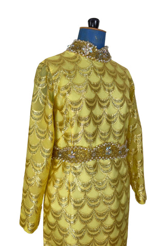 Absolutely stunning true vintage 1960s evening gown in gold metallic figured sheer chiffon, with intricate heavy beading at the high neckline and waist, with large beaded medallion clusters at the tops of the side slits in the skirt. The dress is lined through the bodice and skirt, while the sleeves are left unlined to highlight the sheer gold fabric. 

Designed and made by Fontana’s New York. 

The dress closes in the back with a cotton twill nylon zipper.