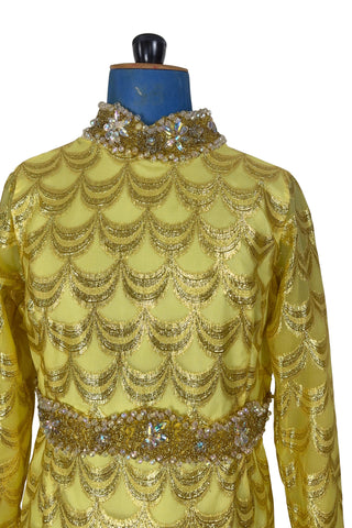 Absolutely stunning true vintage 1960s evening gown in gold metallic figured sheer chiffon, with intricate heavy beading at the high neckline and waist, with large beaded medallion clusters at the tops of the side slits in the skirt. The dress is lined through the bodice and skirt, while the sleeves are left unlined to highlight the sheer gold fabric. 

Designed and made by Fontana’s New York. 

The dress closes in the back with a cotton twill nylon zipper.