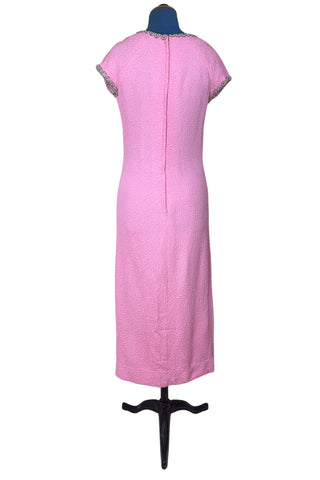 Stunning true vintage 1960s evening gown in candy pink textured crepe with scalloped silver beading at the neckline and trimming the short sleeve cuffs.

The gown is designed with a close-fitting column silhouette, while the textured crepe molds beautifully to your curves.

The gown is fully lined and closes in the back with a cotton twill nylon zipper.