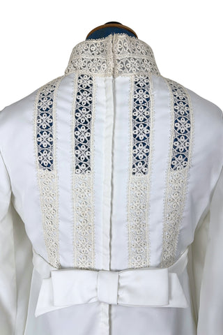 Vintage late 1960s or early 1970s wedding dress with high neck, long sleeves, and an empire waist. This Edwardian revival style dress features crochet lace panels at the neck, down the front and back of the bodice, and trimming the long sleeve cuffs. The dress has a large flat bow at the back of the waist.

Channel your inner Priscilla Presley in this lovely vintage gown.

The dress closes in the back with a cotton twill nylon zipper.