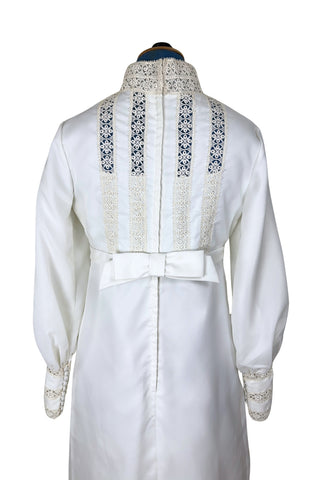 Vintage late 1960s or early 1970s wedding dress with high neck, long sleeves, and an empire waist. This Edwardian revival style dress features crochet lace panels at the neck, down the front and back of the bodice, and trimming the long sleeve cuffs. The dress has a large flat bow at the back of the waist.

Channel your inner Priscilla Presley in this lovely vintage gown.

The dress closes in the back with a cotton twill nylon zipper.
