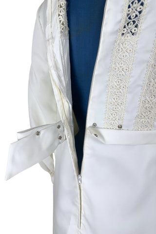 Vintage late 1960s or early 1970s wedding dress with high neck, long sleeves, and an empire waist. This Edwardian revival style dress features crochet lace panels at the neck, down the front and back of the bodice, and trimming the long sleeve cuffs. The dress has a large flat bow at the back of the waist.

Channel your inner Priscilla Presley in this lovely vintage gown.

The dress closes in the back with a cotton twill nylon zipper.
